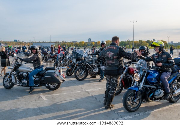Kazan, Russia-September 26,\
2020: One biker energetically greets another in the parking lot at\
a meeting for a biker ride together through the streets of the\
city.
