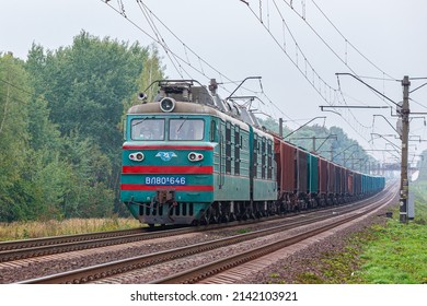 Kazatin, Ukraine - autumn 2021: VL80 locomotive pulls a long train of freight cars loaded with grain and corn to the seaport of Odessa. Freight railway transportation. Ukrainian railway