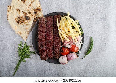 Kebab In Black Plate Tomato, Onion, French Fries And Bread Iraqi Food