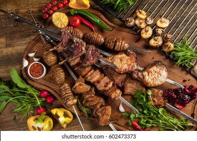 Kebab, chicken wings, 
lamb, pork, potato on skewer. 
Juicy delicious shish kebab on skewers. Baked potatoes, mushrooms, salads and sauces. BBQ. Caucasian cuisine. - Shutterstock ID 602473373