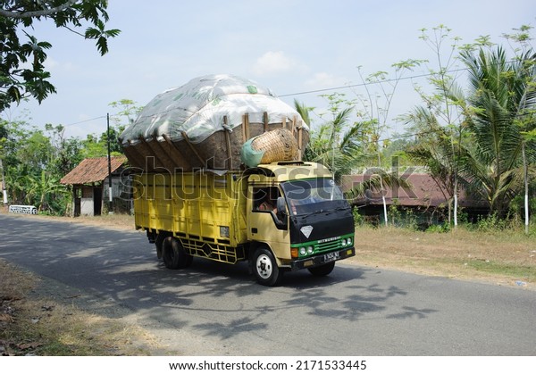 Kebumen, Indonesia - August,\
2015: An overloaded truck crosses a road in Sempor, Kebumen,\
Indonesia.