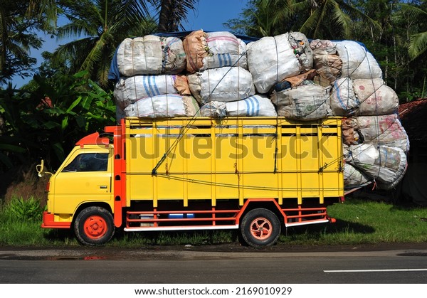 Kebumen, Indonesia - January, 2015: An\
overloaded truck is parked on the side of the\
road.