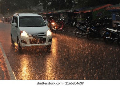 Kebumen, Indonesia - June, 2014: People Drive Under The Rain Near Kebumen Square During The Monsoon In June, 2014.