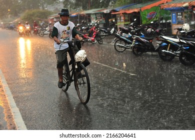 Kebumen, Indonesia - June, 2014: People Drive Under The Rain Near Kebumen Square During The Monsoon In June, 2014.