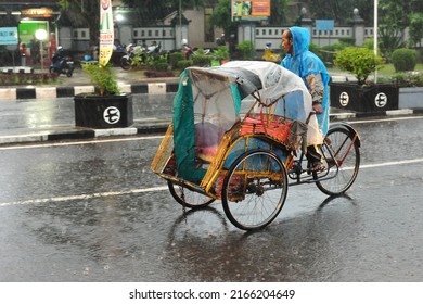 Kebumen, Indonesia - June, 2014: People Drive Under The Rain Near Kebumen Square During The Monsoon In June, 2014.