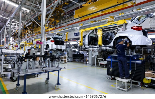 KEDAH, MALAYSIA - JULY 04, 2019 : Workers\
assembles cars at automobile assembly line production plant.\
Catering for both the domestic and export markets industry.\
Automotive &\
technology.