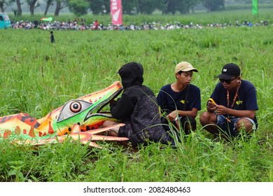 Kediri, East Java, Indonesia - November 21st, 2021 : The Participant Of The Indonesian Kites Festival And Their Kite With Lizard Shape