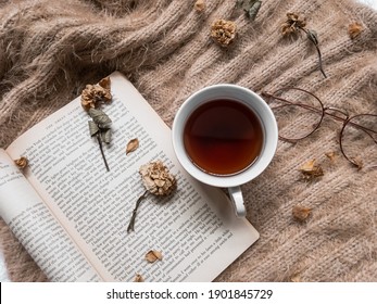 Kediri, Indonesia - January 2021: A Cup Of Tea With Sunglasses, Dried Flowers And A Book Of Page From ‘The Great Gatsby By F. Scott Fitzgerald’ On  Brown Sweater