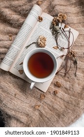 Kediri, Indonesia - January 2021: A Cup Of Tea With Sunglasses, Dried Flowers And A Book Of Page From ‘The Great Gatsby By F. Scott Fitzgerald’ On  Brown Sweater