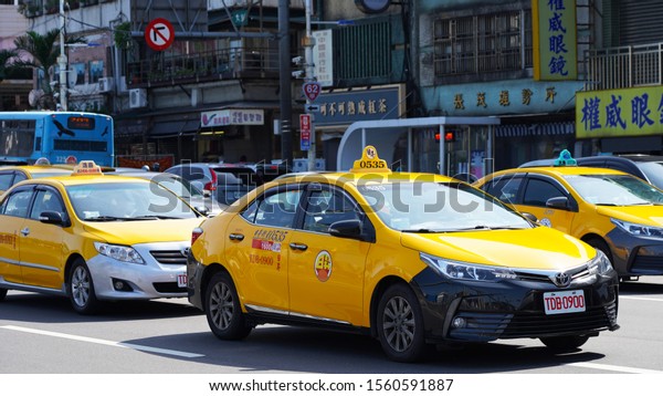 Keelung. Taiwan 11.10.2019\
bright yellow taxi on\
the streets of an asian city. urban street view of taiwan city.\
road traffic on asian streets, road marking. cars taxi mopeds buses\
on the street