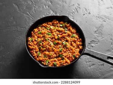Keema curry in cast iron pan on black stone background. Indian and pakistani style dish. Close up view