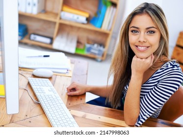 A Keen And Enthusiastic Employee. A Portrait Of An Attractive Young Professional Sitting At Her Desk At Work.