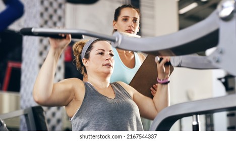 Keep It Going. Cropped Shot Of A Female Fitness Instructor Taking Her Client Through A Workout In The Gym.