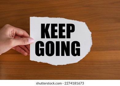 Keep going. Woman hand holds a piece of paper with a note. The way forward, continuity, motivation, positive emotion, inspiration and encouragement.