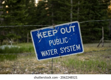 Keep Out Of Public Water System Sign On Barbed Wire Fence