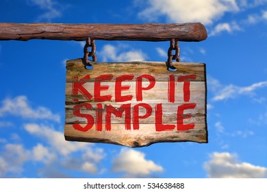 Keep it simple motivational phrase sign on old wood with blurred background