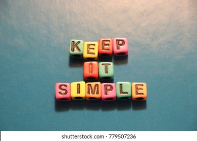 Keep it simple slogan words and letters spelled with colorful alphabet bead blocks.