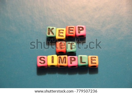 Keep it simple slogan words and letters spelled with colorful alphabet bead blocks.