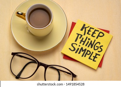 Keep things simple - handwriting on a reminder note with a cup of coffee, efficiency or minimalism concept