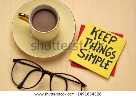 Keep things simple - handwriting on a reminder note with a cup of coffee, efficiency or minimalism concept
