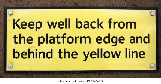 'Keep well back from the platform edge' railway station sign.
