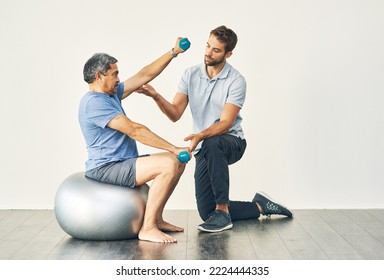 Keep your form. Full length shot of a young male physiotherapist assisting a senior patient in recovery.
