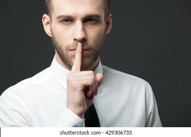 Keep Your Secrets! Studio Portrait Of Young Handsome Businessman Gesturing 