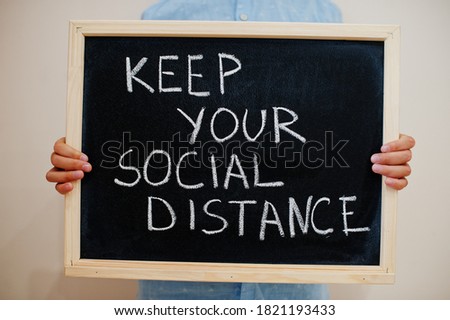 Keep your social distance. Coronavirus concept. Boy hold inscription on the board.