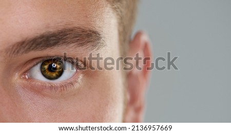 Keeping an eye on the time. Close-up of a mans eye with a clock inside.