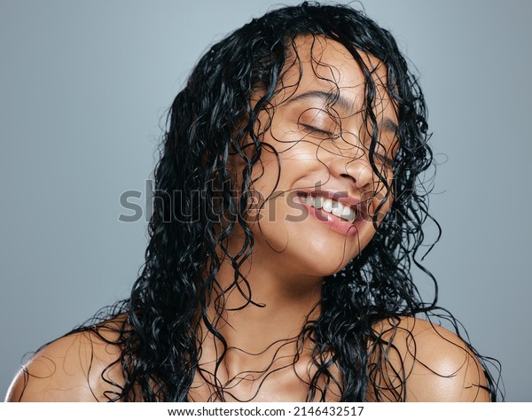 Keeping her mane a head about the rest.\
Studio shot of an attractive young woman posing with wet hair\
against a grey\
background.