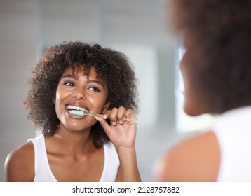 Keeping her smile. Shot of a a young woman brushing her teeth. - Powered by Shutterstock