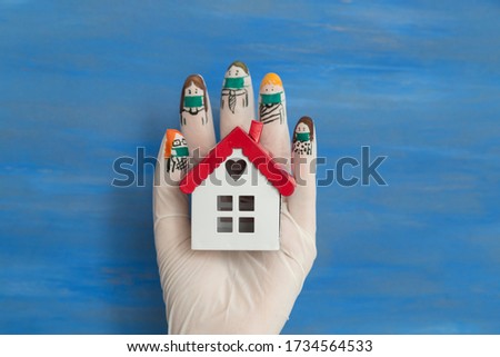 Keeping home with gloved hands , drawing family members on the latex gloves. playing finger puppet game.