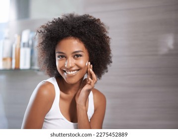 Keeping my skin totally smooth. An attractive young woman applying cream to her face. - Powered by Shutterstock