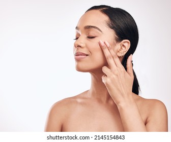 Keeping Our Skin Healthy And Moist Is Of Utmost Importance. Studio Shot Of A Beautiful Young Woman Applying Moisturiser To Her Face.