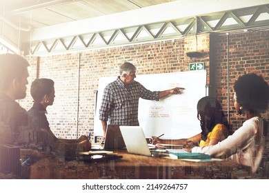 Keeping Up With Their Game Plan. Shot Of A Businessman Giving A Presentation To His Colleagues In An Office.