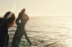Keeping The Vibe Going. Shot Of A Group Of Young Surfers Surfing Together In The Ocean.