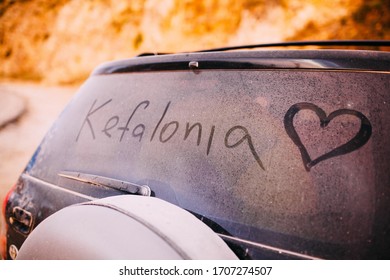 Kefalonia Word Written On A Dusty Car Window With A Heart Drawing.