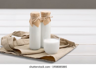 Kefir, Buttermilk Or Yogurt In Glass On Wooden Desk