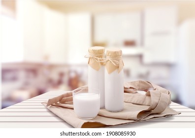 Kefir, Buttermilk Or Yogurt In Glass On Wooden Desk