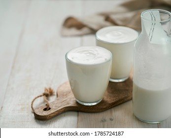 Kefir, Buttermilch oder Jogurt mit Probiotika. Jogurt aus Glas auf weißem Holzhintergrund. Probiotische kalte fermentierte Milchgetränke. Gesundheit der Tiere, fermentierte Produkte, Konzept der gesunden Darmflora. Leerzeichen kopieren