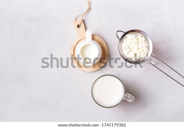 Kefir fermented\
milk drink with kefir grains. Homemade kefir stands in a glass,\
next to kefir grains and milk on a gray concrete background.\
Horizontal orientation. Bulgarian\
drink.