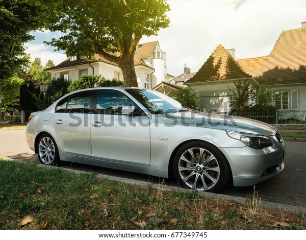 KEHL, GERMANY - JUL 14, 2017: Silver BMW\
luxury limousine sedan parked in city with luxury real estate\
building in the background beautiful german house\
