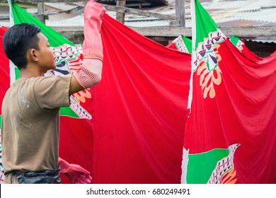 KELANTAN, MALAYSIA - 15TH JULY 2017; Unidentified man hanging a batik for drying process after painting by hand. A traditional batik making is a famous tourist attraction  in Malaysia.