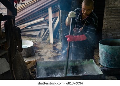 KELANTAN, MALAYSIA - 15TH MAY 2017; Unidentified man wash a batik in boiled water as part of traditional process for making Batik in Kelantan.