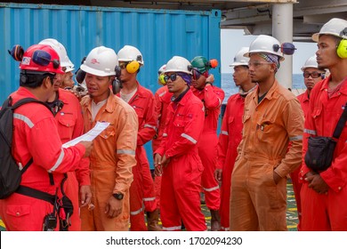 KELANTAN, MALAYSIA - AUG  15TH 2019 : Unidentified offshore workers with full personal protective equipment (PPE) standing and line up to check attendance prior to start work at oil and gas platform.