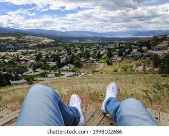 Kelowna, British Columbia, Canada- 20 June, 2021: A Photo Of A Person With Chuck Taylors Sneakers Hiking To Top Of Black Mountain Hill Top Viewpoint In Kelowna, Okanagan Valley Overseeing Lake 