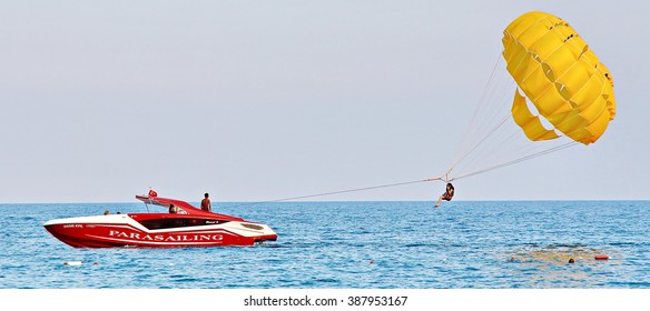 KEMER, TURKEY - AUGUST 14, 2015: Parasailing in a blue sky near sea beach. Parasailing is a popular recreational activity among tourists in Turkey. For editorial use only.

