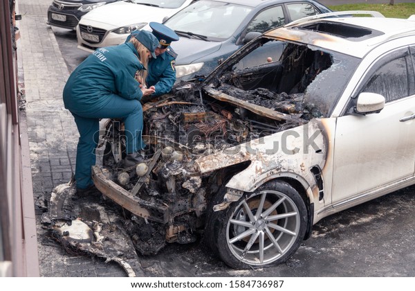 Kemerovo 2019-09-16 forensic experts, police,\
emergency services do inspection, expertise of white abandoned car\
Infiniti FX50S burned out. Concept arson, crime, attempt, terrorist\
attack
