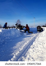 Kemerovo, Kemerovo Region, Russia - 01.31.2021 On A Winter Road, Two Men Pull Out A Snowmobile Stuck In The Snow.