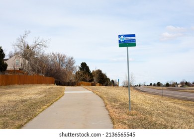 Ken Caryl, Colorado, USA,March 10, 2022,Jefferson county bikeway sign and concrete path surrounded by winter grass and blue sky